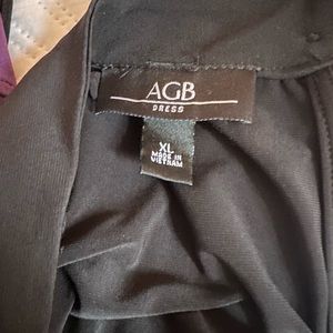 Plain black dress with red/pink flower in the top left of dress.